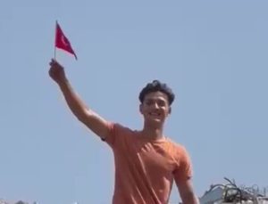 Hatay’da hurda yığını içerisindeki Türk bayrağını elleriyle çıkararak iş makinesine astı