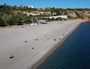 Antalya’da güneşli hava keyfi: Denize girip güneşlendiler