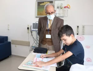 Nezih öğretmen, yatılı tedavi gören çocukların başucunda ders işliyor